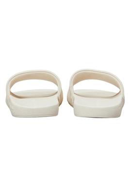 Chinelos Calvin Klein de monograma bege para mulher.